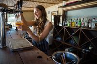 barmaid-pouring-beer-from-tap-in-glass-at-bar-2021-08-28-16-46-49-utc